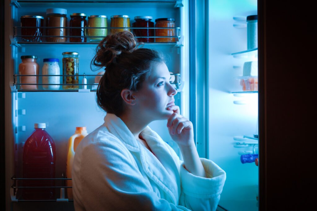 Woman looking in fridge at night